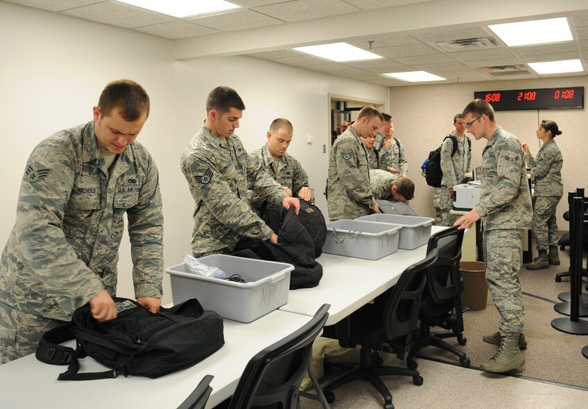 Barksdale Airmen prepare their gear before processing through a checkpoint on Barksdale Air Force Base, La., Aug. 30, 2013. The Airmen deployed in support of the continuous bomber presence in the pacific, a standing Air Force Global Strike Command deterrence mission. (U.S. Air Force photo/Senior Airman Benjamin Gonsier)