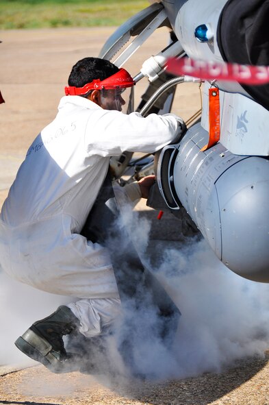 Senior Airman Hector Artigas, 482nd FW crew chief, services the oxygen tank on an F-16 at Barksdale AFB during Operation Green Flag, Aug. 28. (U.S. Air Force Photo/ tech. Sgt. Lou Burton)