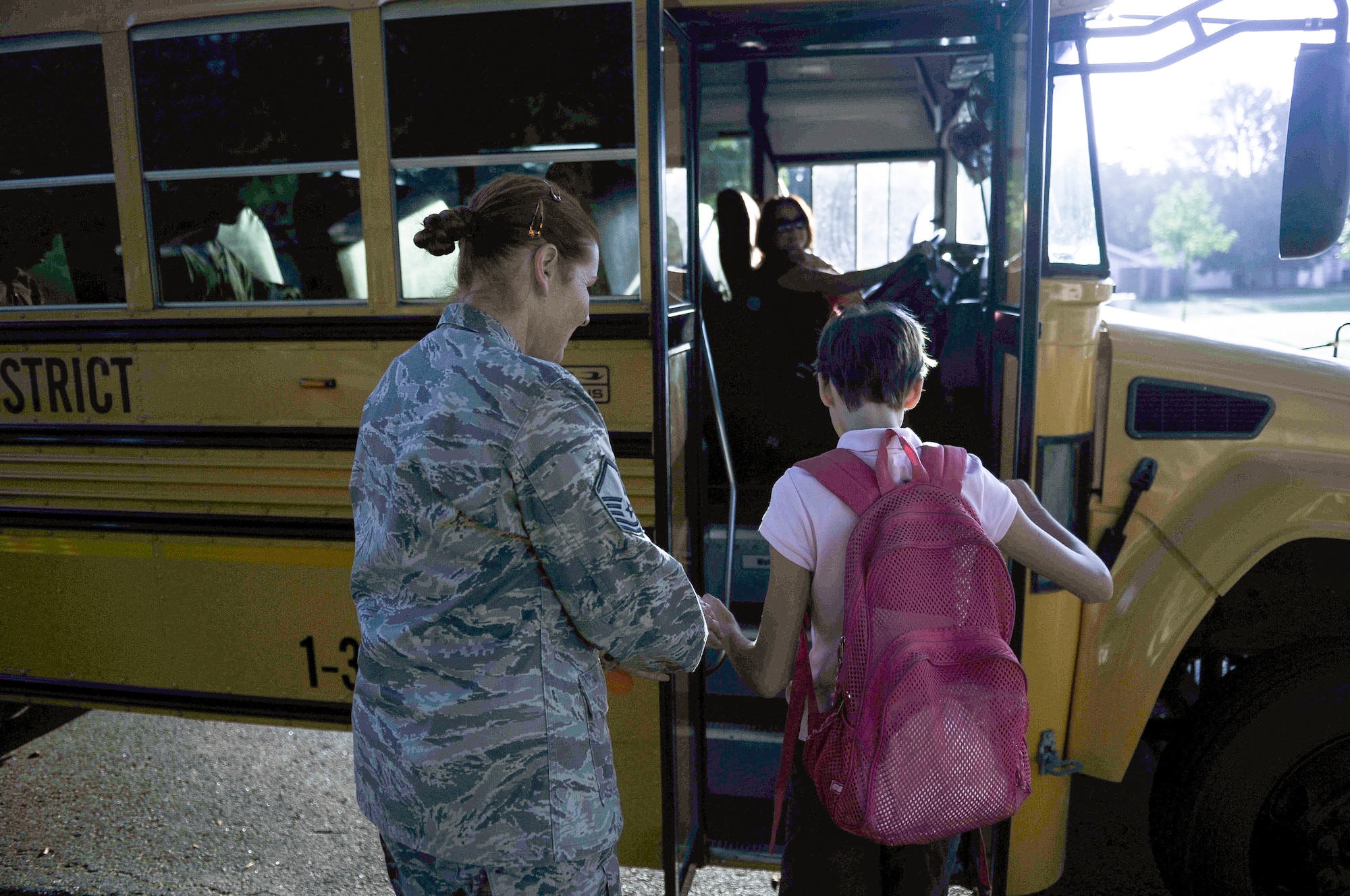 Master Sgt. Beth Jungk, a 19th Communications Squadron plans and programs manager, walks her daughter Morgan to her school bus Aug. 23, 2013, outside their home in Jacksonville, Ark. Getting Morgan ready for school on time in the morning is challenging for Beth, who has to get ready for work while making sure Morgan is taken care of. Beth is planning to retire from the military next year and hopes the change will provide more stability for her and Morgan. (U.S. Air Force photo by Staff Sgt. Jake Barreiro)