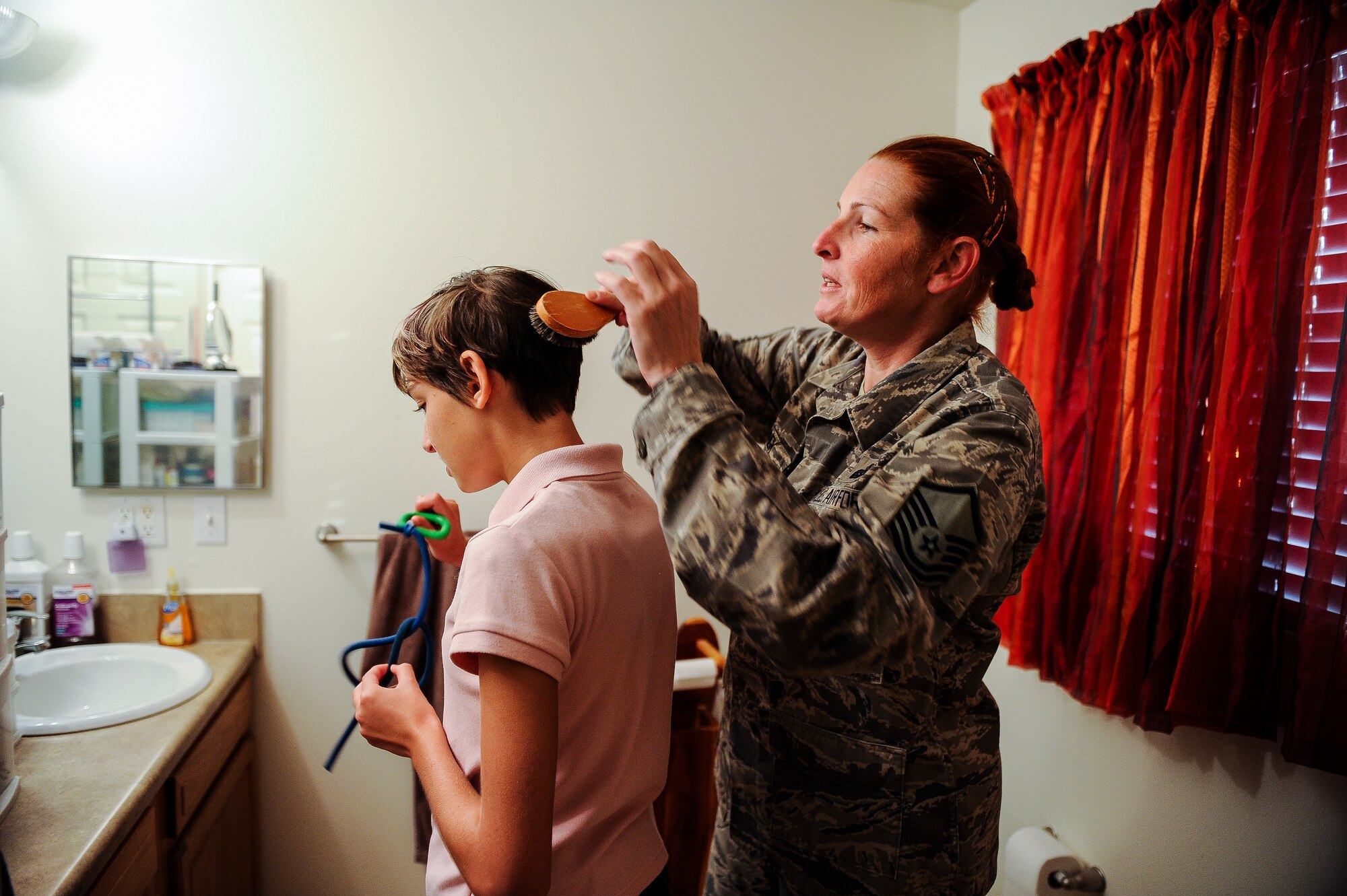 Master Sgt. Beth Jungk, a 19th Communications Squadron plans and programs manager, brushes her daughter, Morgan’s, hair Aug. 23, 2013, at their home in Jacksonville, Ark. Beth has to fully clothe and groom Morgan every day before school in addition to getting ready for work herself. (U.S. Air Force photo by Staff Sgt. Jake Barreiro)