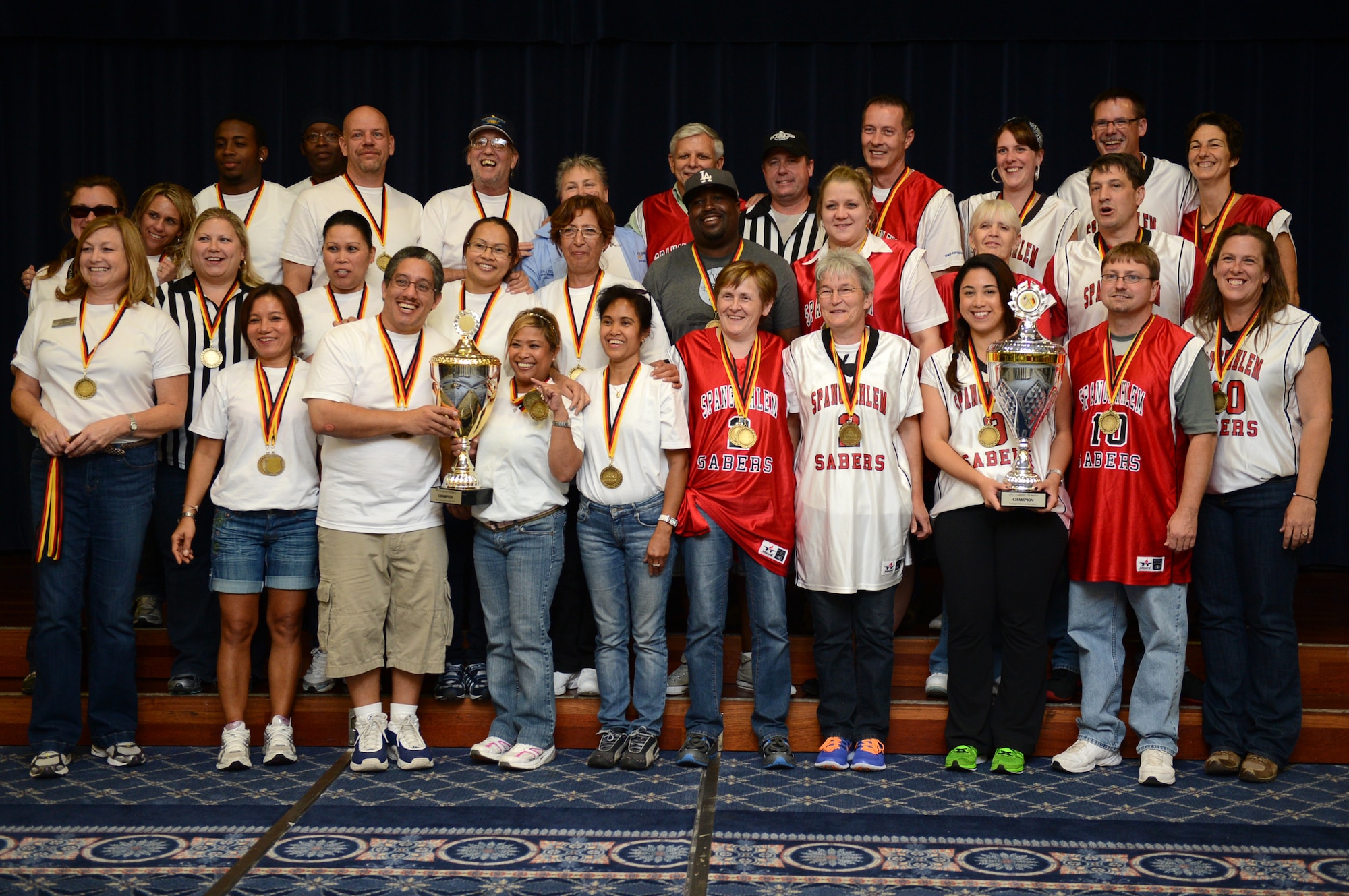 SPANGDAHLEM AIR BASE, Germany -- Ramstein and Spangdahlem Air Bases’ lodging facility employees receive their participation medals and trophies as part of the Lodging Olympics hosted at the Eifel Club Aug. 29, 2013. Spangdahlem won overall in the afternoon-long competition. (U.S. Air Force photo by Senior Airman Alexis Siekert/Released))