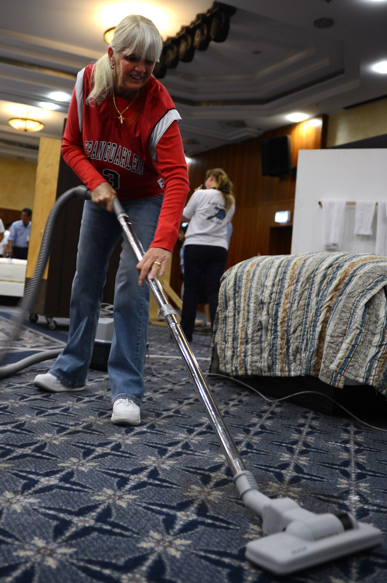 SPANGDAHLEM AIR BASE, Germany -- Marilyn Gasper, 52nd Force Support Squadron, vacuums the floor during the vacuum and dusting event of the Lodging Olympics hosted at the Eifel Club Aug. 29, 2013. The competition between lodging employees from Spangdahlem and Ramstein Air Bases acts as a team-building exercise for all sections and offers a chance for base leadership to recognize the difficulties of lodging operations. (U.S. Air Force photo by Senior Airman Alexis Siekert/Released)
