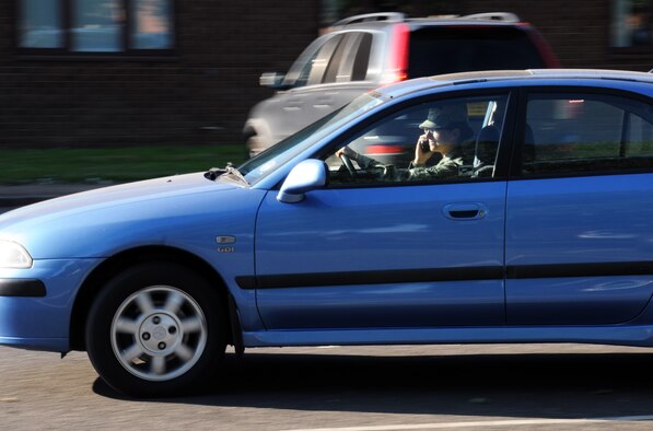 Using a cell phone while driving is a danger to everyone. It can reduce reaction times, possibly causing an accident. Safety spotters are encouraged to report this kind of behavior. [(Note: The photo has been staged to depict the dangers of unsafe driving.) (U.S. Air Force photo by Gina Randall/Released)]