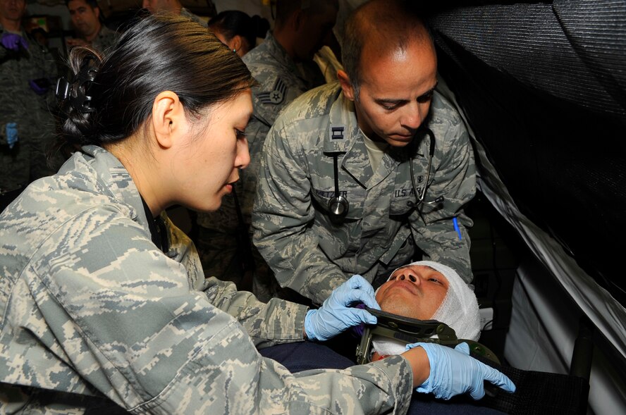 U.S. Air Forces in Europe and Air Forces Africa medical unit members place a neck brace on an injured patient during Expeditionary Medical Support training Aug. 28, 2013, Ramstein Air Base, Germany. EMEDS training is conducted to prepare Airmen for humanitarian missions. (U.S. Air Force photo/Airman Dymekre Allen) 