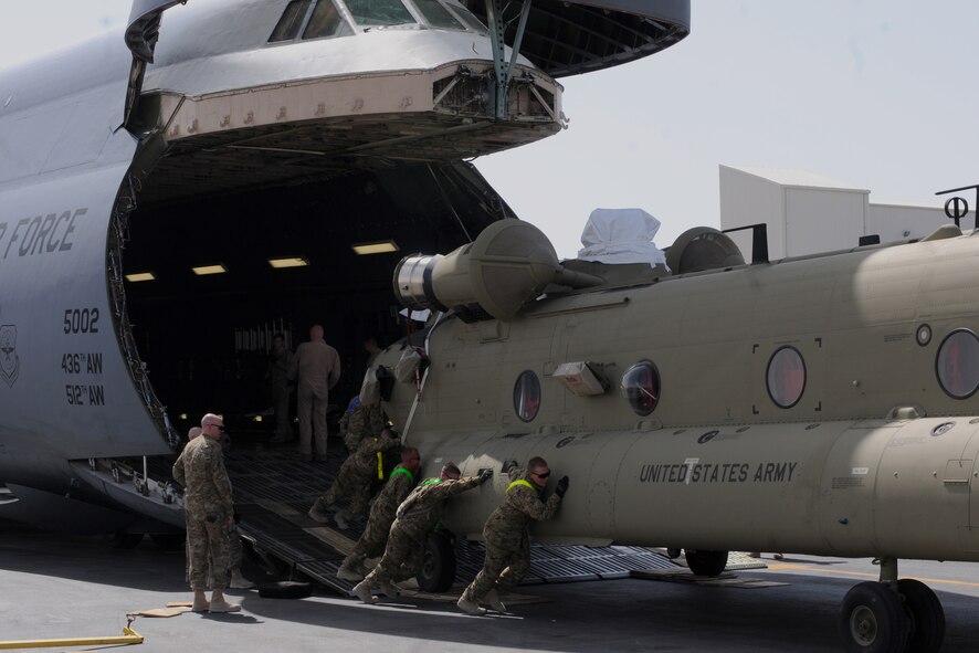 Soldiers from Bravo Company, 601st Aviation Support Battalion, 1st Combat Aviation Brigade, push a Chinook helicopter off a C-5M Super Galaxy at Kandahar Airfield, Afghanistan, Aug. 24, 2013. Using C-5A Galaxys from the 433rd Airlift Wing at Lackland Air Force Base, Texas, and Super Galaxys from Dover Air Force Base, Del., Airmen moved more than 120 helicopters as part of a multi-modal mission to swap out equipment as part of the rotation between the 1st and 3rd CABs here. (U.S. Air Force photo/Capt. Brian Maguire)
