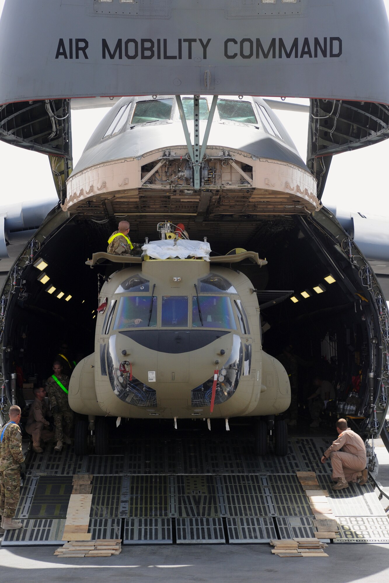Airmen from the 9th Airlift Squadron and Soldiers from Bravo Company, 601st Aviation Support Battalion, 1st Combat Aviation Brigade, unload a Chinook helicopter from a C-5M Super Galaxy at Kandahar Airfield, Afghanistan, Aug. 24, 2013. The Chinooks arrived via a multi-modal mission to swap out equipment as part of the rotation between the 1st and 3rd CABs here. (U.S. Air Force photo/Capt. Brian Maguire)