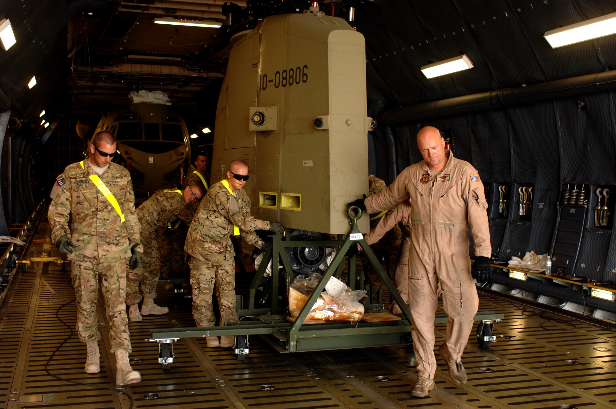 Airmen from the 9th Airlift Squadron and Soldiers from Bravo Company, 651st Aviation Support Battalion, 1st Combat Aviation Brigade, unload a Chinook helicopter power plant from a C-5M Super Galaxy from Dover Air Force Base, Del., at Kandahar Airfield, Afghanistan Aug. 24, 2013. During a three-week timeframe in August, C-5 aircrew moved more than 120 helicopters to support the 1st Combat Aviation Brigade as they replace the 3rd Combat Aviation Brigade here. (U.S. Air Force photo by Senior Airman Jack Sanders)