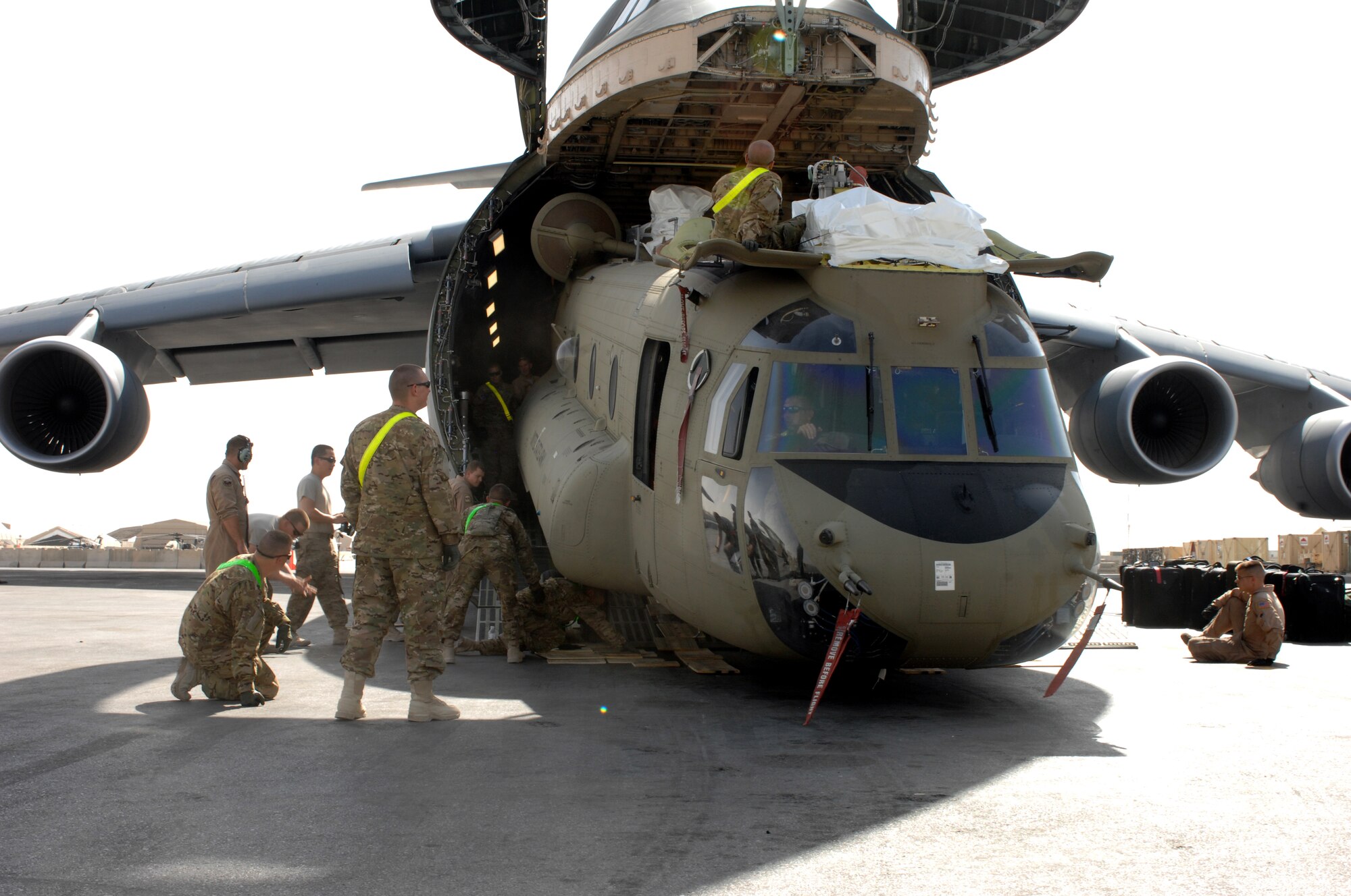 A Chinook helicopter is unloaded from a C-5M Super Galaxy from Dover Air Force Base, Del., at Kandahar Airfield, Afghanistan, Aug. 24, 2013. The Chinook is from the 1st Combat Aviation Brigade. C-5 Galaxys were used as part of a multi-modal mission to swap out equipment as the 1st CAB replaced the 3rd CAB here. (U.S. Air Force photo by Senior Airman Jack Sanders)
