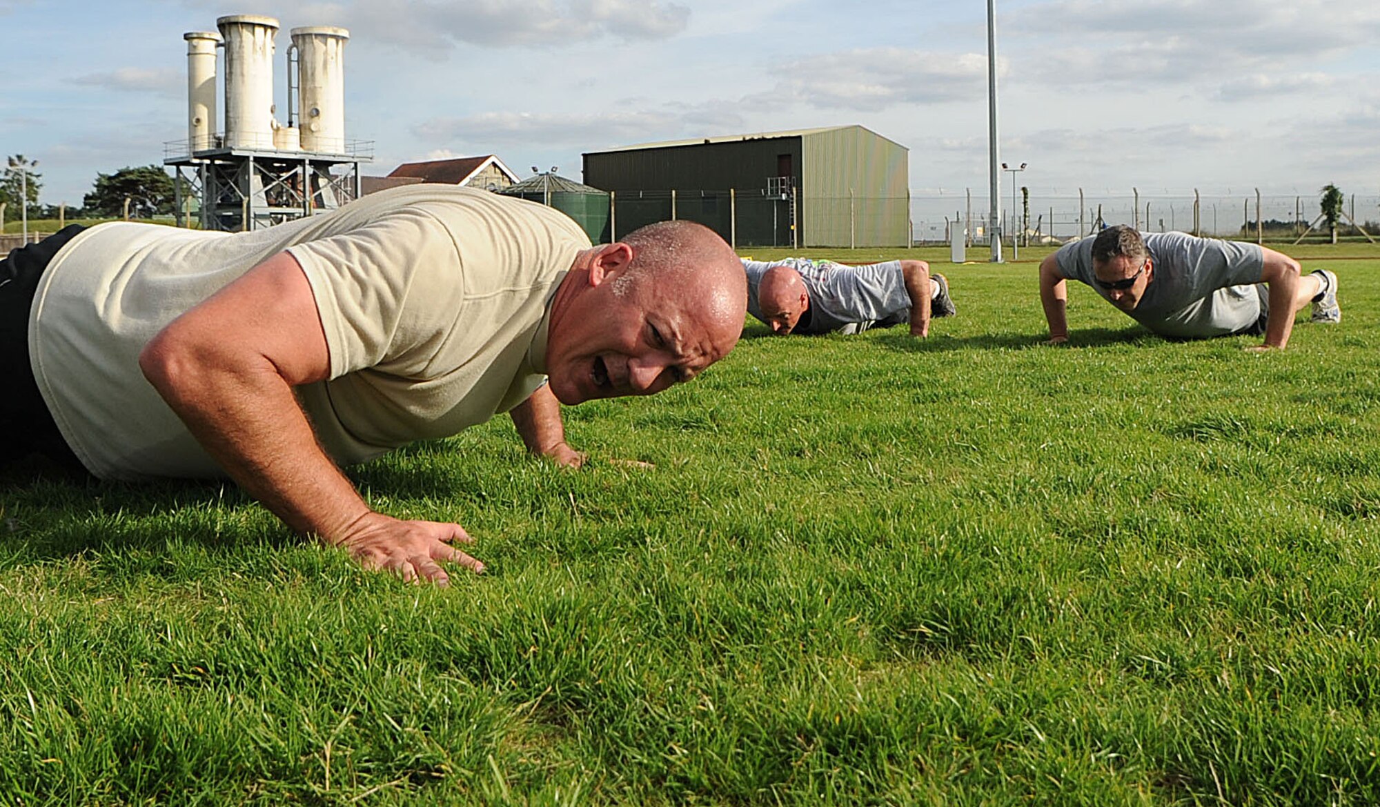 U.S. Air Force Chief Master Sgt. William Markham, 352nd Special Operations Group command chief, counts out nine push-ups Aug. 29, 2013, before a final silent memorial pushup to remember and honor fallen Airmen after the Chiefs vs. Eagles Monster Mash at Heritage Park on RAF Mildenhall, England. Team Mildenhall commanders competed against chief master sergeants to complete several challenges. Base leaders gained a better sense of teamwork, leadership and followership while working together to overcome the challenges in the monster mash. (U.S. Air Force photo by Airman 1st Class Preston Webb/Released)