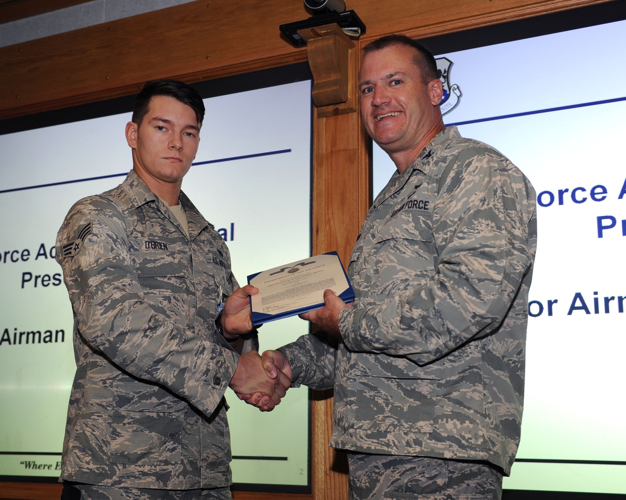 U.S. Air Force Col. Kenneth T. Bibb Jr., right, 100th Air Refueling Wing commander, awards U.S. Air Force Senior Airman Barry O’Brien, 100th Security Forces Squadron response force leader from Kingsford, Mich., with an Air Force Achievement Medal and a certificate Aug. 28, 2013, on RAF Mildenhall, England, to recognize O’Brien’s life-saving efforts. O’Brien and four other Airmen responded to an off-base vehicle accident July 22, 2013, and utilized their first-responder training to assist three injured British nationals until emergency services arrived. (U.S. Air Force photo by Airman 1st Class Preston Webb/Released)
