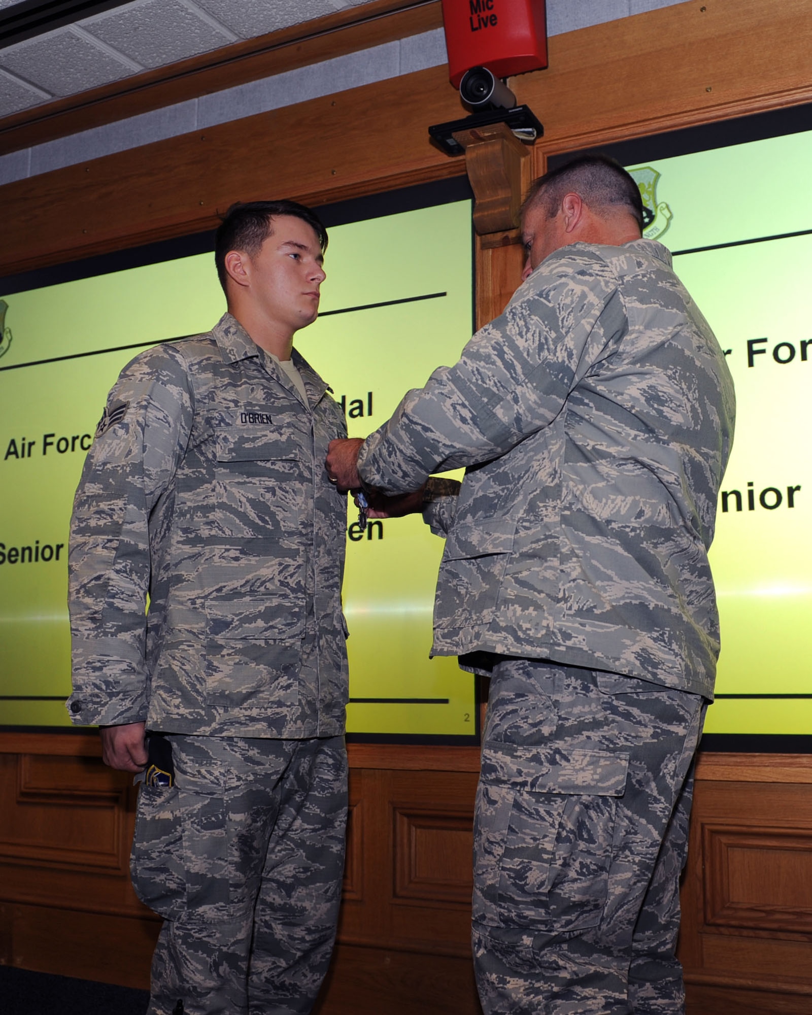 U.S. Air Force Col. Kenneth T. Bibb Jr., right, 100th Air Refueling Wing commander, awards U.S. Air Force Senior Airman Barry O’Brien, 100th Security Forces Squadron response force leader from Kingsford, Mich., an Air Force Achievement Medal Aug. 28, 2013, on RAF Mildenhall, England, to recognize O’Brien’s life-saving efforts. O’Brien and four other Airmen responded to an off-base vehicle accident July 22, 2013, and utilized their first-responder training to assist three injured British nationals until emergency services arrived. (U.S. Air Force photo by Airman 1st Class Preston Webb/Released)