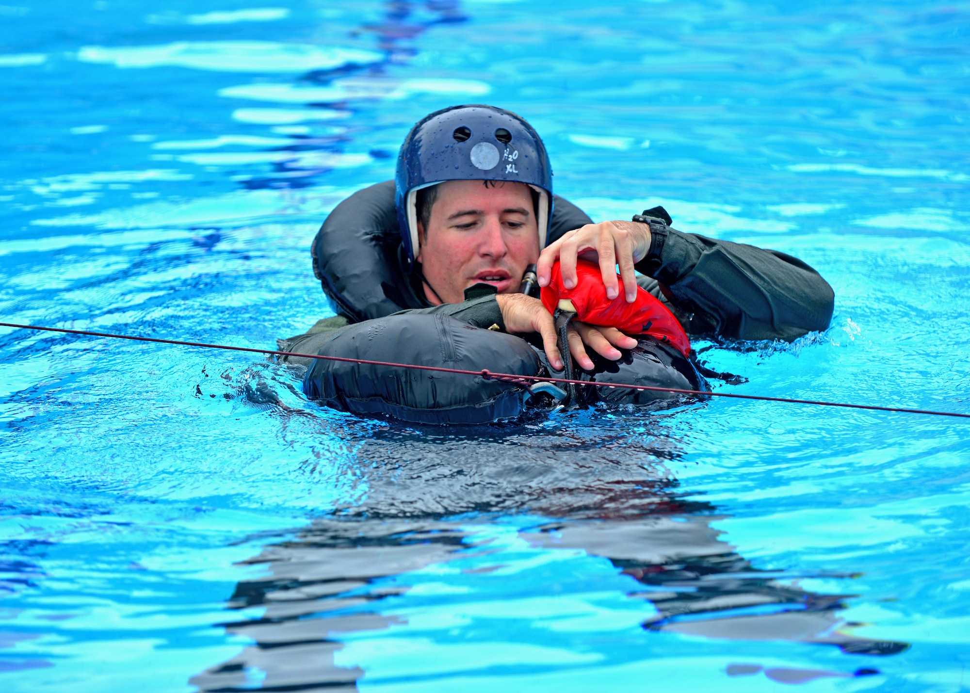 Capt. Andrew Littel, 31st Operations Support Squadron ground liaison officer, hooks himself onto a recovery device during water survival training, Aug. 26, 2013, at Aviano Air Base, Italy. Water-survival training occurs three months out of the year and teaches attendees how to survive in the water after an aircraft crash. (U.S. Air Force photo/Airman 1st Class Briana Jones)