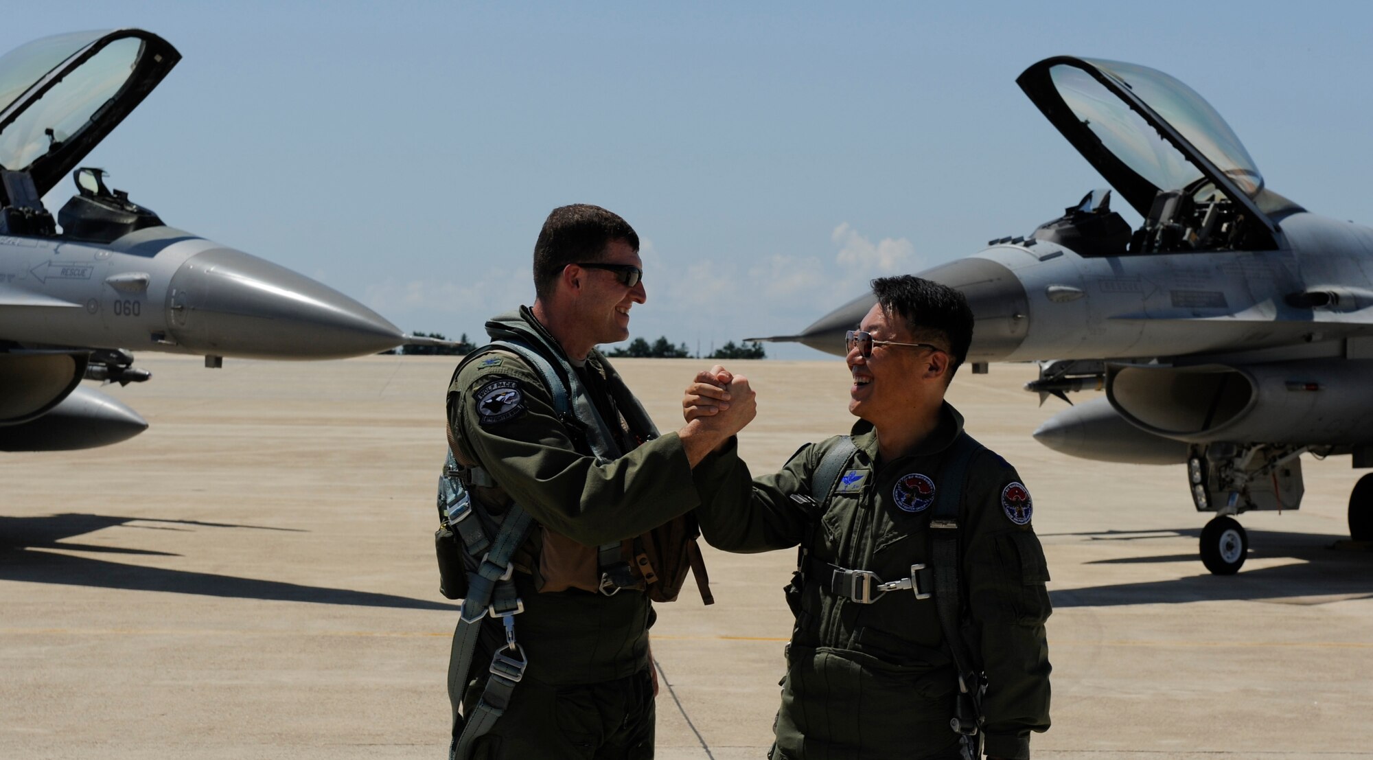 KUNSAN AIR BASE, Republic of Korea -- Colonel S. Clinton Hinote, 8th Fighter Wing commander, left, and Republic of Korea air force Col. Min-Oh Seo, 38th Fighter Group commander, greet each other beside their F-16 Fighting Falcons after a friendship flight Aug. 14, 2013. For more than 60 years, Airmen from the U.S. Air Force and ROKAF have built and maintained partnerships through events like these. (U.S. Air Force photo by Senior Airman Armando A. Schwier-Morales/ Released)