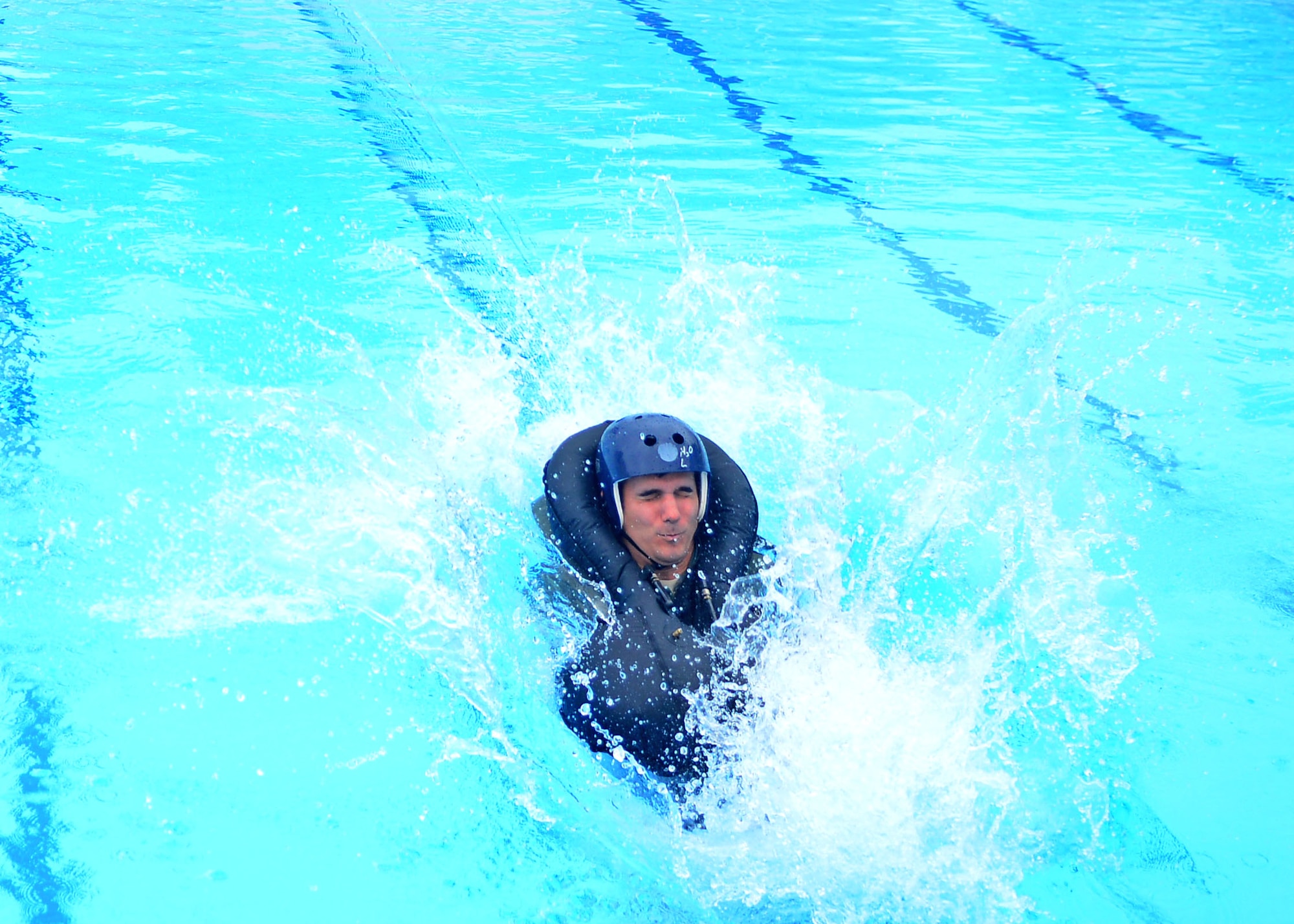 1st Lt. John Lamonaca, 555th Fighter Squadron intelligence chief, jumps in the pool during water-survival training, Aug. 26, 2013, at Aviano Air Base, Italy. During training, Lamonaca was dragged by a motor to simulate a parachute drag that could occur when ejecting over water. (U.S. Air Force photo/Airman 1st Class Briana Jones)