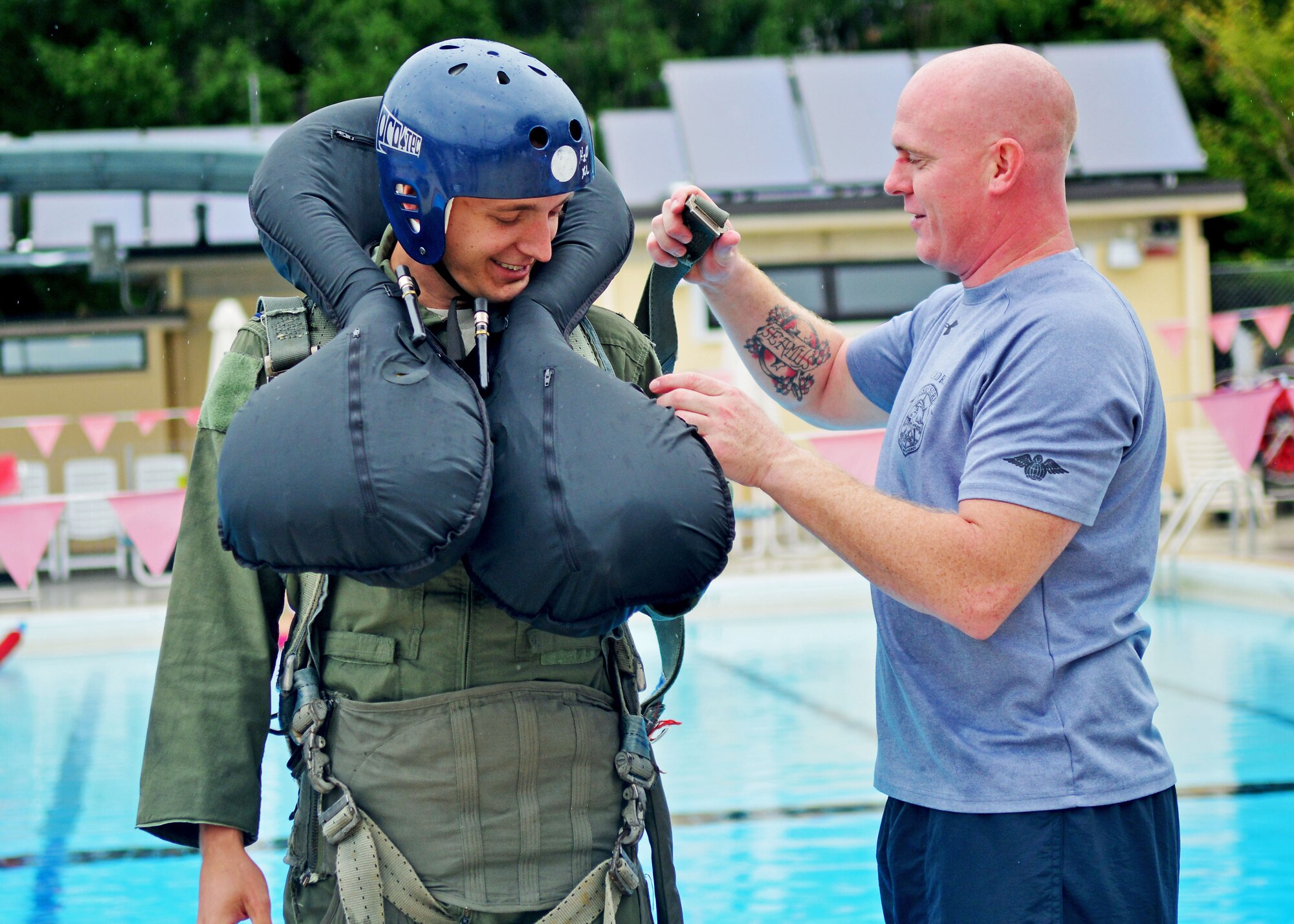 Staff Sgt. Isaac Denton (right), 31st Operations Support Squadron Survival, Evasion, Resistance and Escape specialist helps adjust Capt. Eric Broyles, 555th Fighter Squadron F-16 Fighting Falcon pilot harness during water-survival training, Aug. 26, 2013, at Aviano Air Base, Italy. Water-survival training teaches individuals to take care of any injuries received during an ejection, exposure prevention, how to stay dry to prevent immersion injuries, and navigation techniques. (U.S. Air Force photo/Airman 1st Class Briana Jones)