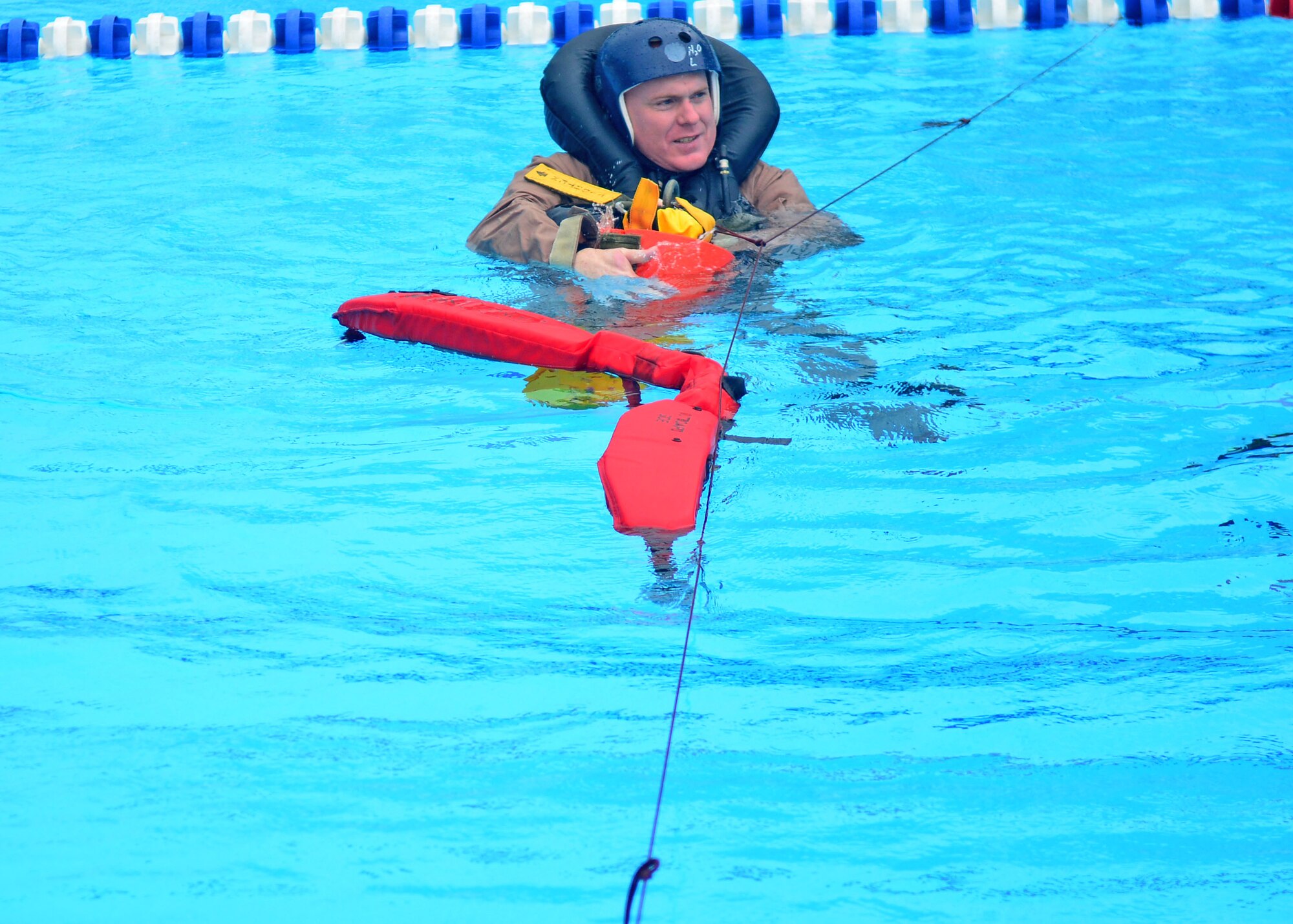 Staff Sgt. Isaac Denton, 31st Operations Support Squadron Survival, Evasion, Resistance and Escape specialist, demonstrates how to hook himself onto a training recovery device during  water-survival training, Aug. 26, 2013, at Aviano Air Base, Italy. The training teaches individuals how to survive in the water after an aircraft crash. (U.S. Air Force photo/Airman 1st Class Briana Jones)
