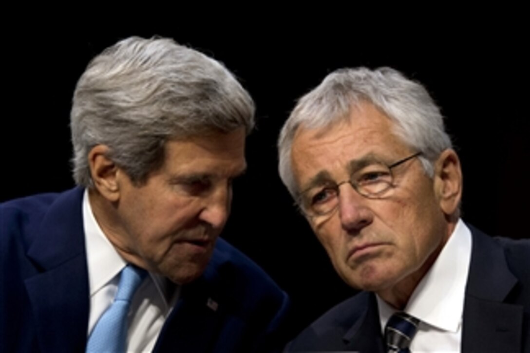Secretary of State John F. Kerry, left, confers with Secretary of Defense Chuck Hagel during testimony on U.S. military intervention in Syria before the Senate Foreign Relations Committee at the Senate Hart Office Building in Washington, D.C., on Sept. 3, 2013.  Chairman of the Joint Chiefs of Staff Gen. Martin E. Dempsey joined Kerry and Hagel for the testimony.  