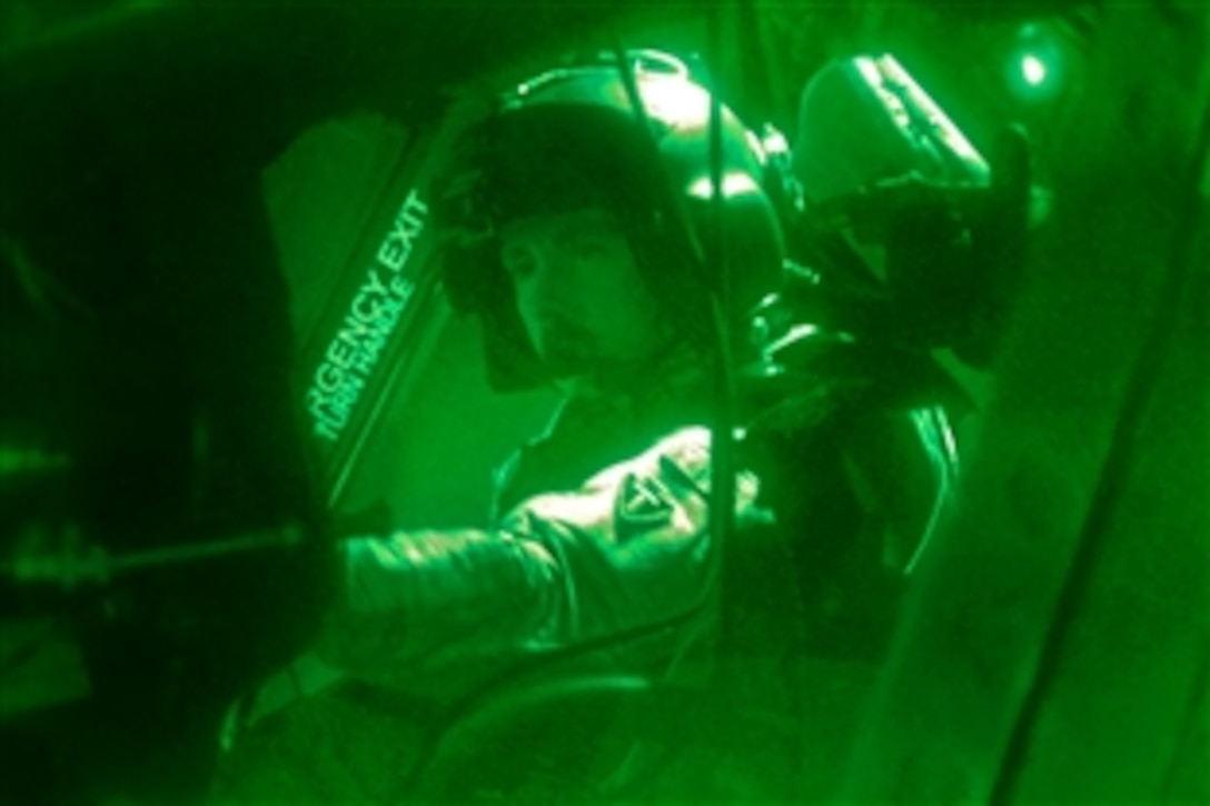 As seen through a night-vision device, U.S. Army Chief Warrant Officer 4 Robert Cudd prepares his equipment before a personnel and equipment movement mission on Bagram Airfield, Afghanistan, Aug. 31, 2013. Cudd, a pilot, is assigned to Company B, 2nd Battalion General Support, 36th Combat Aviation Brigade.