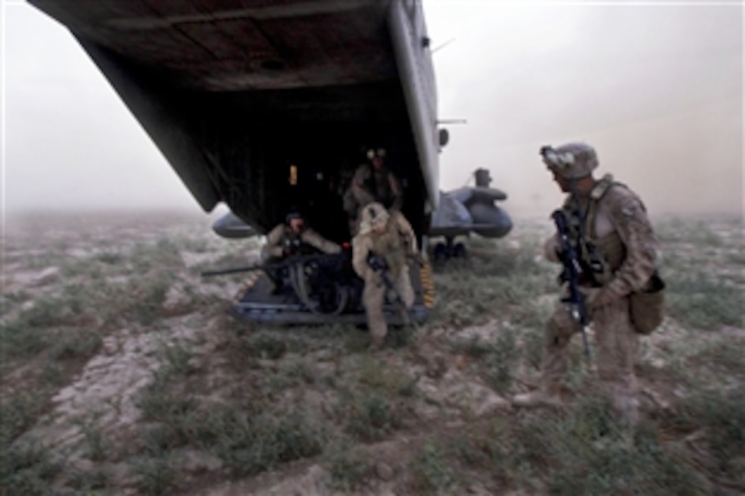 U.S. Marines, Afghan forces and British soldiers exit a CH-53E Super Stallion helicopter at Qal'ah-ye Badam in Helmand province, Afghanistan, Aug. 31, 2013.