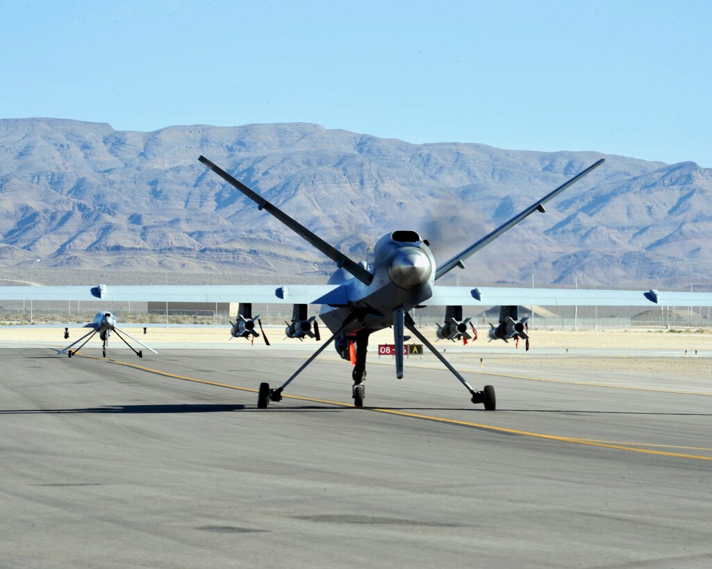 CREECH AIR FORCE BASE, Nev. – An MQ-1 Predator and MQ-9 Reaper prepare for takeoff on the Creech Air Force Base, Nev., flightline July 18, 2013. Both aircraft are armed, multi-mission, medium-altitude, long-endurance remotely piloted aircraft that are employed primarily as intelligence-collection asset and secondarily against dynamic execution targets. 
