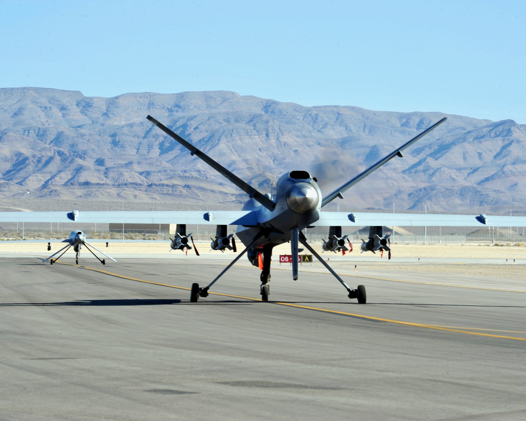 CREECH AIR FORCE BASE, Nev. – An MQ-1 Predator and MQ-9 Reaper prepare for takeoff on the Creech Air Force Base, Nev., flightline July 18, 2013. Both aircraft are armed, multi-mission, medium-altitude, long-endurance remotely piloted aircraft that are employed primarily as intelligence-collection asset and secondarily against dynamic execution targets. 
