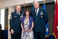Lt. Gen. Harry Wyatt, Director of the Air National Guard, National Guard Bureau, Washington, D.C., presents the Chief of Staff of the Air Force award for exceptional public service to Monique Muncy, wife of Chief Master Sgt. Christopher E. Muncy, Command Chief Master Sergeant of the Air National Guard, National Guard Bureau, Washington, D.C., during Chief Muncy's retirement luncheon at Joint Base Anacostia-Bolling. Muncy retired after thirty-five years of service to his country and held the position of Command Chief Master Sergeant of the Air National Guard since May 2009.