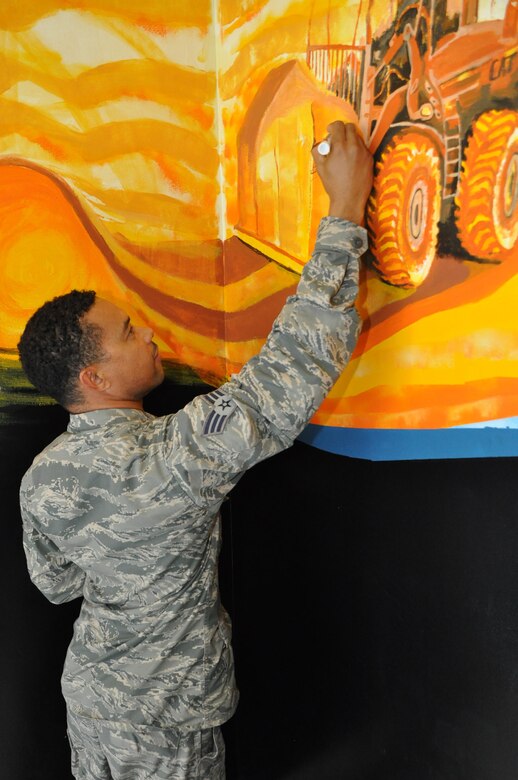 Senior Airman Sean Connolly, air transportation specialist, 69th Aerial Port Squadron, signs his signature on the mural he painted in the stairwell at the entrance of 69 APS here at Joint Base Andrews, Md. The mural highlights the different aspects of the aerial port mission and took more than six months for him to complete.  