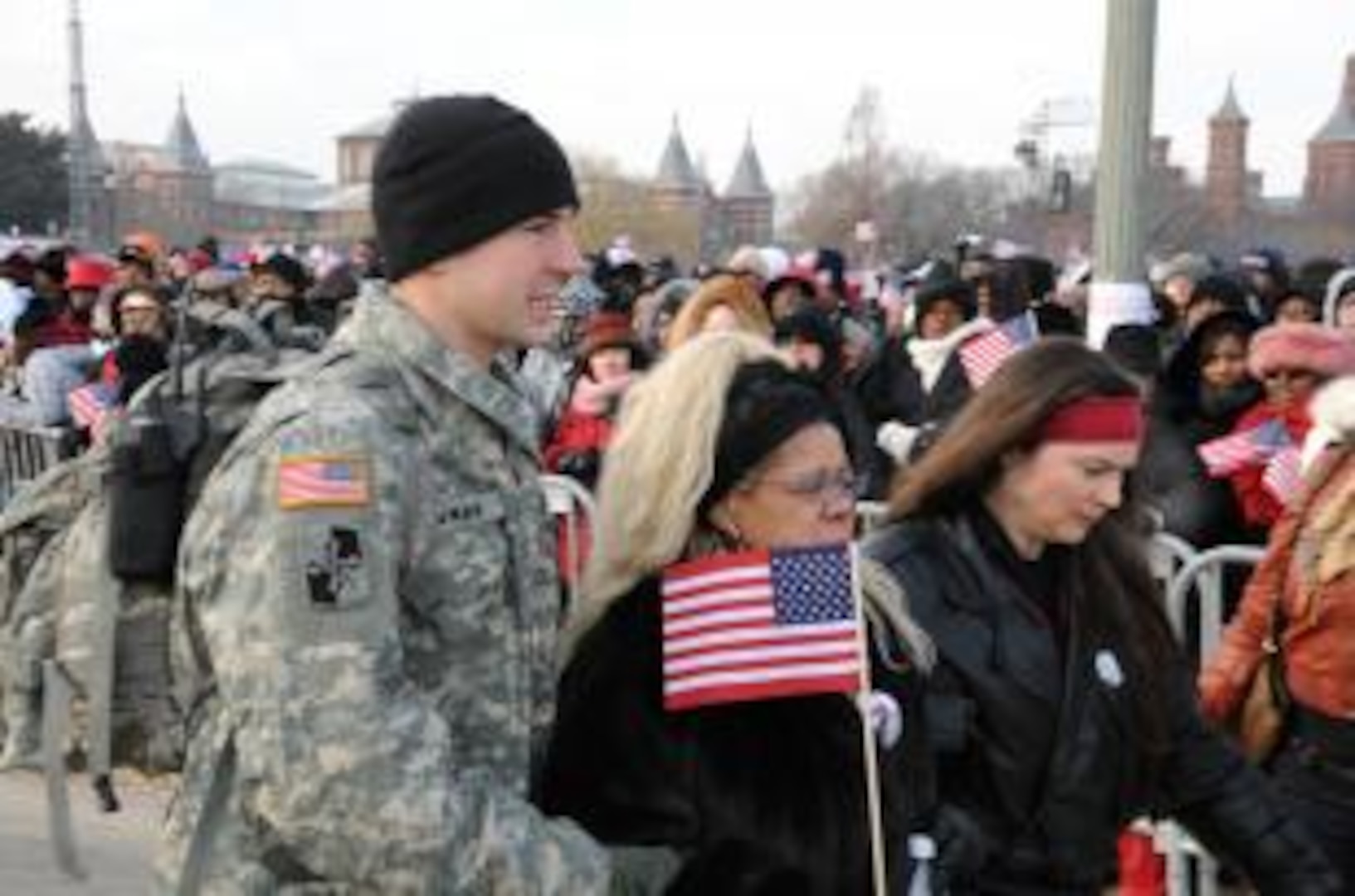 A member of the Army National Guard escorts two women as they rush by the crowds during the 56th Presidential Inauguration, Jan. 20, 2009.