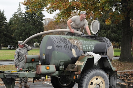 Staff Sgt. Robert Nieratko, top, and Pfc. Michael McAteer, both with the 50th Infantry Brigade Combat Team, New Jersey Army National Guard, fill a water buffalo with potable water in preparation for Hurricane Sandy at the National Guard Armory in Lawrenceville, N.J., Oct. 26, 2012.