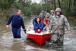 Virginia National Guard Soldiers transport citizens through high water to reach their medium tactical truck for evacuation on Cattail Road in the Mears, Va. area Oct. 30.