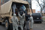 New York Army National Guard Soldiers from Company F, 427th Brigade Support Battalion, along with New York State Troopers, help residents arriving at Long Beach City Hall in Long Beach, N.Y., for evacuation to shelters.