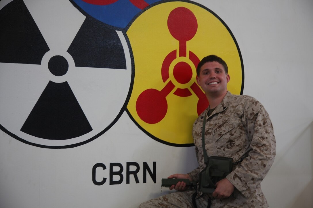 Corporal Jayun Thibodeaux, a chemical, biological, radiological and nuclear defense specialist with Combat Logistics Regiment 17, 1st Marine Logistics Group, poses with an APU-77 personal radiation detector aboard Camp Pendleton, Calif., Aug. 27, 2013. Marines with CBRN train 20 percent of Marines per regiment on how to detect, contain and utilize proper decontamination techniques. 