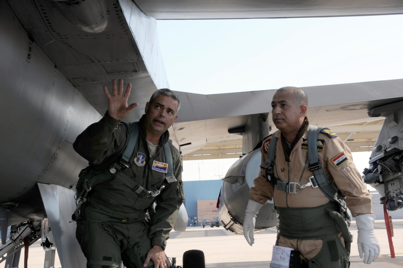 Air Force Col. Andrew MacDonald, commander of the Arizona Air National Guard's 162nd Operations Group, goes over pre-flight checks of an F-16D Fighting Falcon aircraft with Iraqi Air Force Brig. Gen. Abdulhussein Lafta Ali Ali before an orientation flight at Tucson International Airport Aug. 30. Abdulhussein, with a delegation of senior Iraqi officers, visited the international F-16 training wing where Iraqi pilots are learning to fly the multi-role fighter.