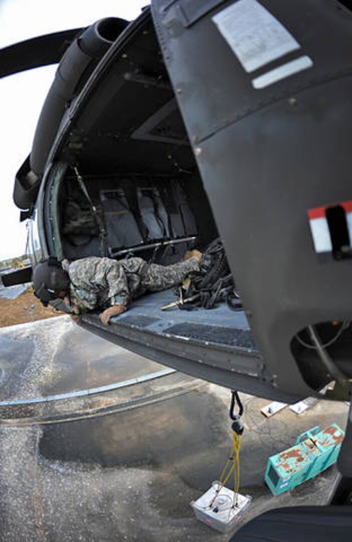 A Louisiana Army National Guard UH-60 Black Hawk helicopter piloted by Chief Warrant Officer 4 Matt Krutzfeldt lowers a container holding 300 gallons of fuel to supply a generator for the local water treatment plant in Port Sulphur, La., Sept. 5, 2012.