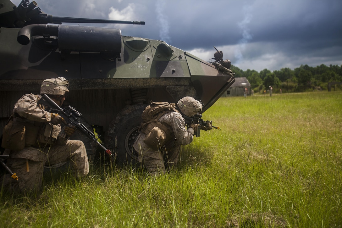 U.S. Marines with Battalion Landing Team (BLT) 1st Battalion, 6th Marine Regiment, 22nd Marine Expeditionary Unit’s (MEU) light armored reconnaissance company raid a compound during a motorized raid course at Marine Corps Base Camp Lejeune, N.C., Aug. 20, 2013. Approximately 120 Marines in more than 20 light armored vehicles worked alongside Alpha Co., BLT 1/6, during the weeklong field exercise. The MEU is scheduled to deploy in early 2014 to the U.S. 5th and 6th Fleet areas of responsibility with the Bataan Amphibious Ready Group as a sea-based, expeditionary crisis response force capable of conducting amphibious missions across the full range of military operations. (U.S. Marine Corps photo by Sgt. Austin Hazard/Released)