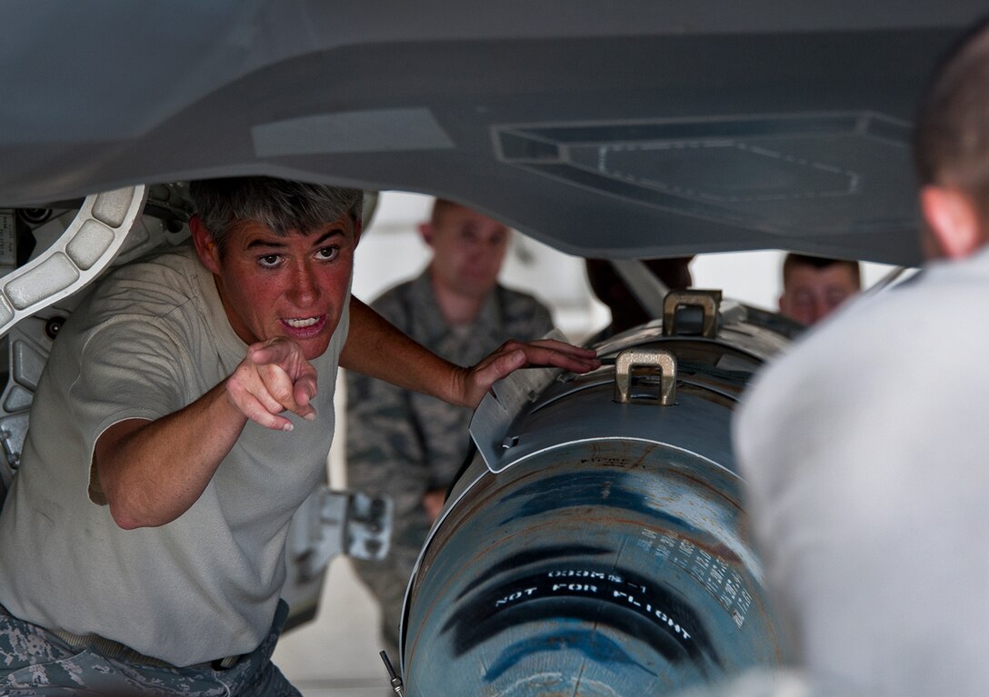 Master Sgt. Karen Griffin informs the jammer drive which way to turn to get the GBU -31 into position to be loaded onto an F-35A Lightning II Aug. 27, 2013, at Eglin Air Force Base, Fla. This marked the first time Airmen have loaded weapons onto the new joint strike fighter at Eglin AFB. The weapons load procedures perfected by the 33rd Maintenance Group Airmen will be taught to maintenance students in the future. Griffin is assigned to the 33rd MXG. (U.S. Air Force photo/Samuel King Jr.) 