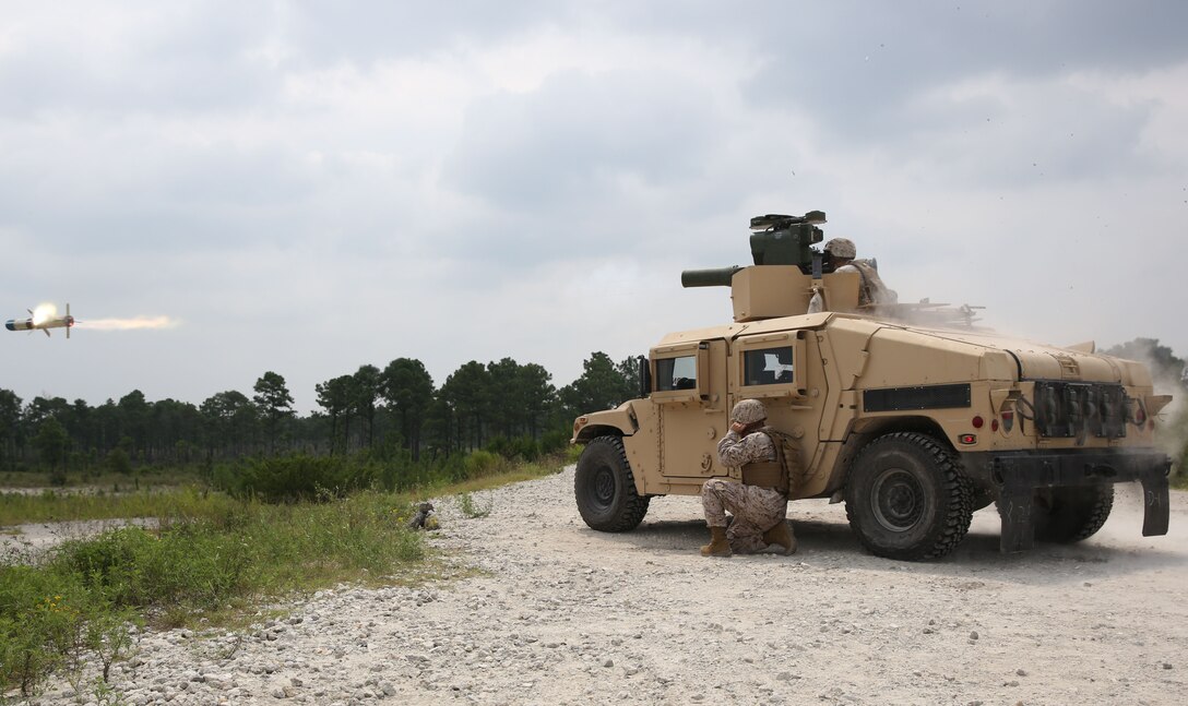 Chief Warrant Officer 2 Eric M. Brown, the battalion gunner, for 2nd Battalion 9th Marine Regiment kneels beside the Humvee as the BGM-71 Tube-launched, Optically-tracked, Wire-guided missile is fired, August 29, 2013. Each TOW missile is approximately $10,000, said Brown. 