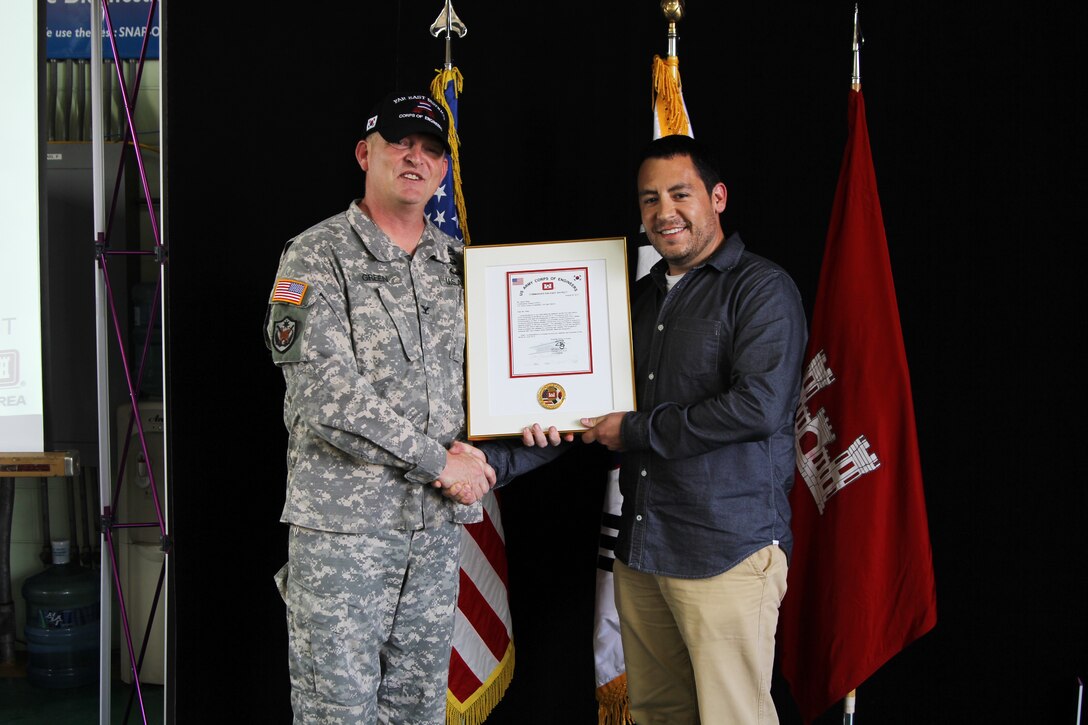 Civil Engineer Jacob West receives the Chief of Engineers 2011 Military Contingency Responder of the Year award from Col. Bryan S. Green, U.S. Army Corps of Engineers Far East District commander, on behalf of Chief of Engineers Lt. Gen. Thomas P. Bostick, Aug. 30.   West received the award for his service in Afghanistan between late 2010 and 2012.  