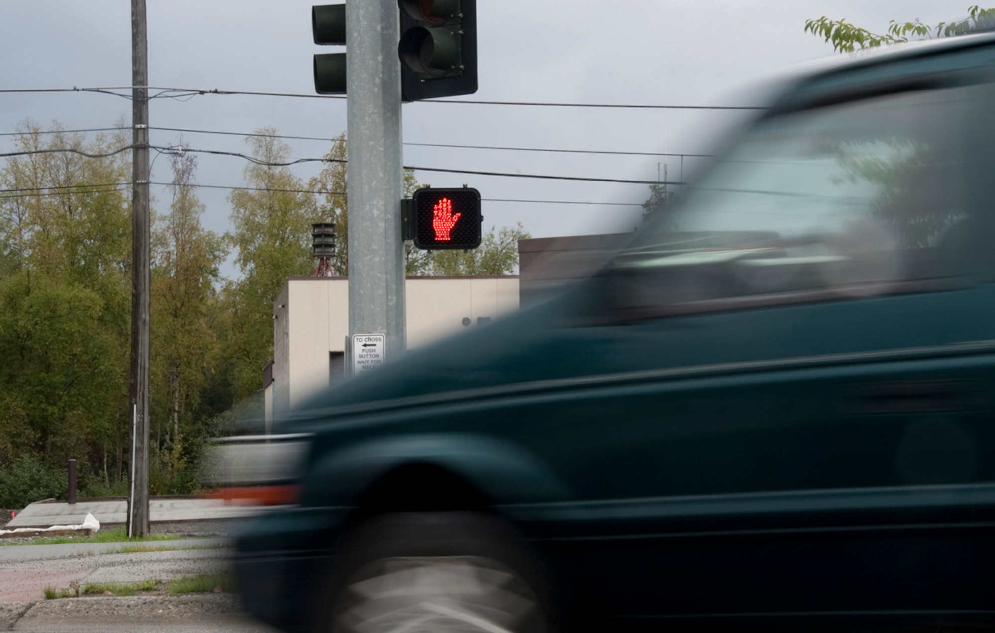 A green minivan passes a stop light on Joint Base Elmendorf-Richardson, Sept. 4, 2013. Most vehicle accidents on JBER involve privately-owned vehicles, occur in parking lots and are due to speeding and inattentive driving. (U.S. Air Force photo/Staff Sgt. William Banton)