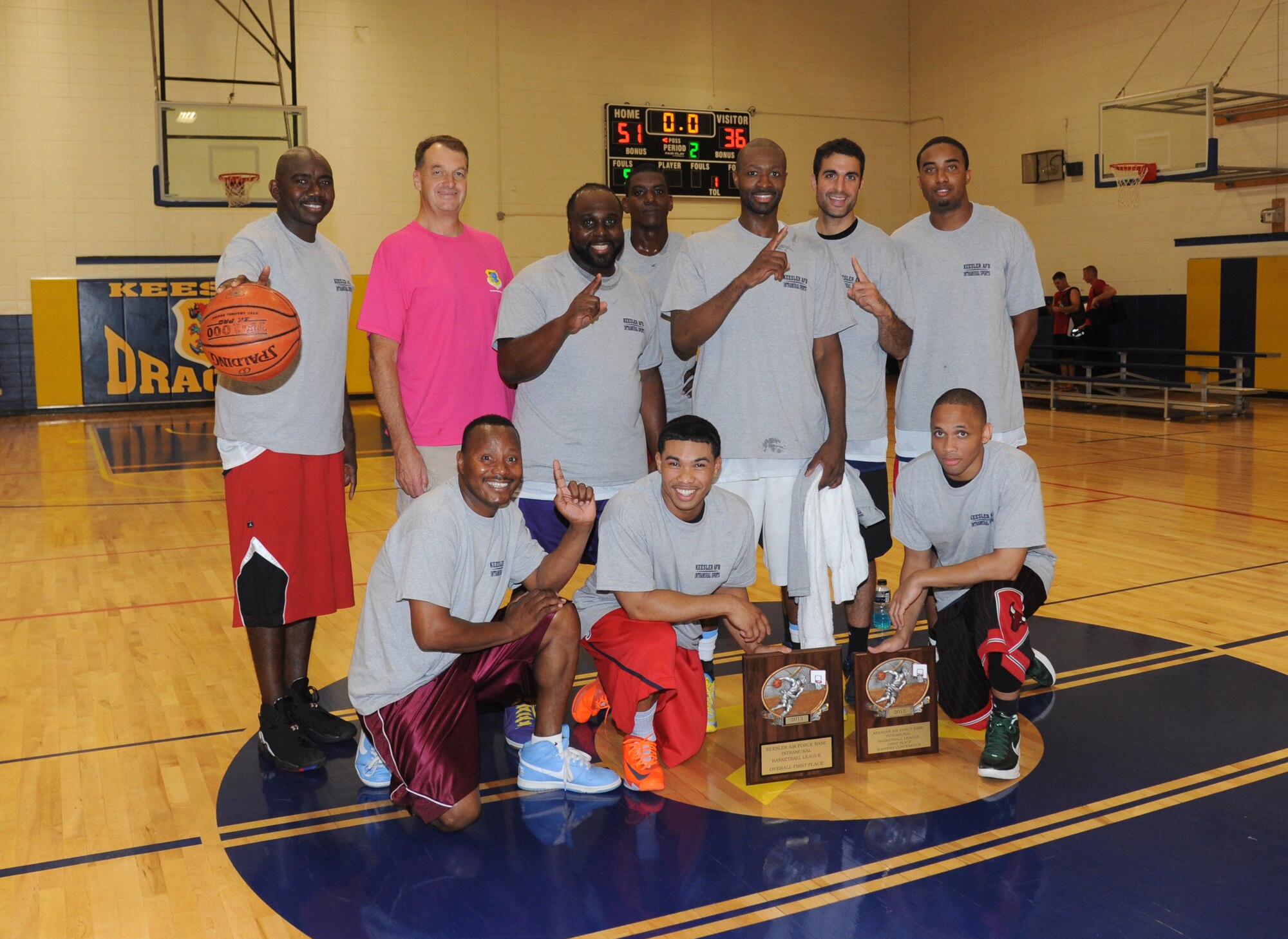 Brig. Gen. Kory Cornum, 81st Medical Group commander, (pink shirt), takes a group photo with the 81st MDG intramural basketball championship team following the game against the 335th Training Squadron Sept. 4, 2013, Keesler Air Force Base, Miss. The 81st MDG defeated the 335th TRS, 51-36.  (U.S. Air Force photo by Kemberly Groue)