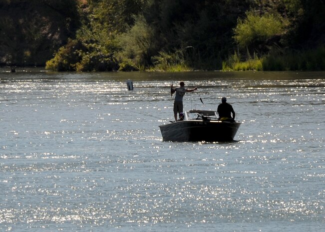 A fisherman hauls in a fish during a fishing tournament supporting local Wounded Warriors on the Sacramento River near North Sacramento Calif., Aug. 24, 2013. Balfour Beatty hosted the tourney to promote Beale’s Wounded Warriors. (U.S. Air Force photo by Staff Sgt. Robert M. Trujillo/Released)