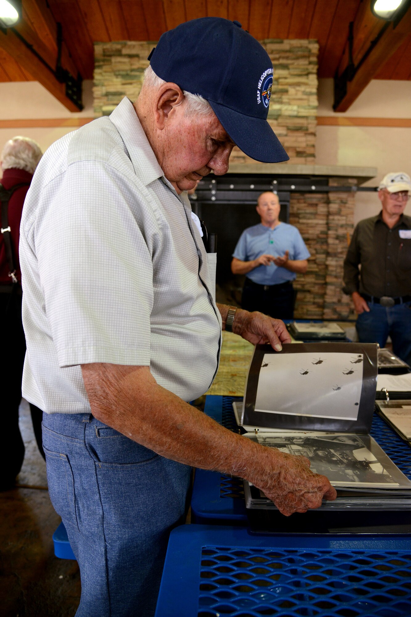 Shirrel Martin, a former 20th Helicopter Squadron commander, flips through a 40th Helicopter Squadron photo album during a tour Aug. 27 at Sun Plaza Park. Martin served during the Vietnam War and retired as a lieutenant colonel in 1977. (U.S. Air Force photo/Staff Sgt. R.J. Biermann)