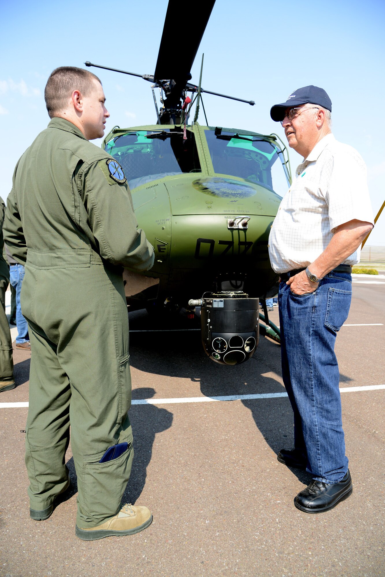 Staff Sgt. Aaron Goodloe, a 40th Helicopter Squadron scheduler, shows Glenn Hunter the infrared camera on a UH-1N Huey helicopter during a tour Aug. 27 at Sun Plaza Park. Hunter served as a crew chief in the 20th Helicopter Squadron during the Vietnam War. He later retired from active duty as a technical sergeant. (U.S. Air Force photo/Staff Sgt. R.J. Biermann)
