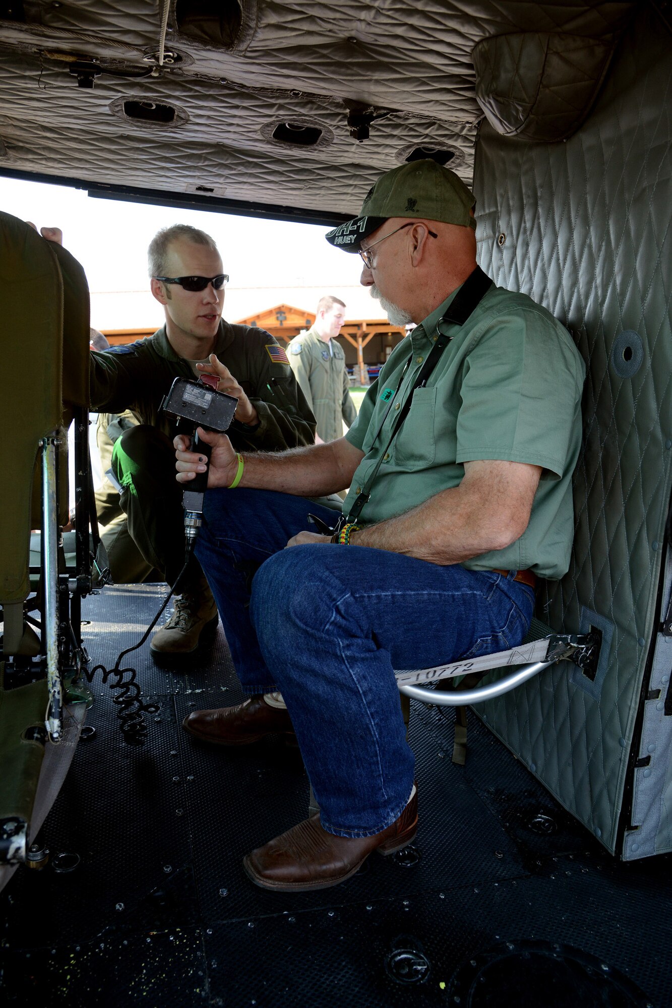 Capt. David Operchal, a 40th Helicopter Squadron UH-1N Huey helicopter pilot, shows Ron Wells the inside of a UH-1N on Aug. 27 at Sun Plaza Park. Wells, a former 20th Helicopter Squadron Sikorsky CH-3C helicopter flight engineer and door gunner, was an enlisted Airman during the Vietnam war. (U.S. Air Force photo/Staff Sgt. R.J. Biermann)
