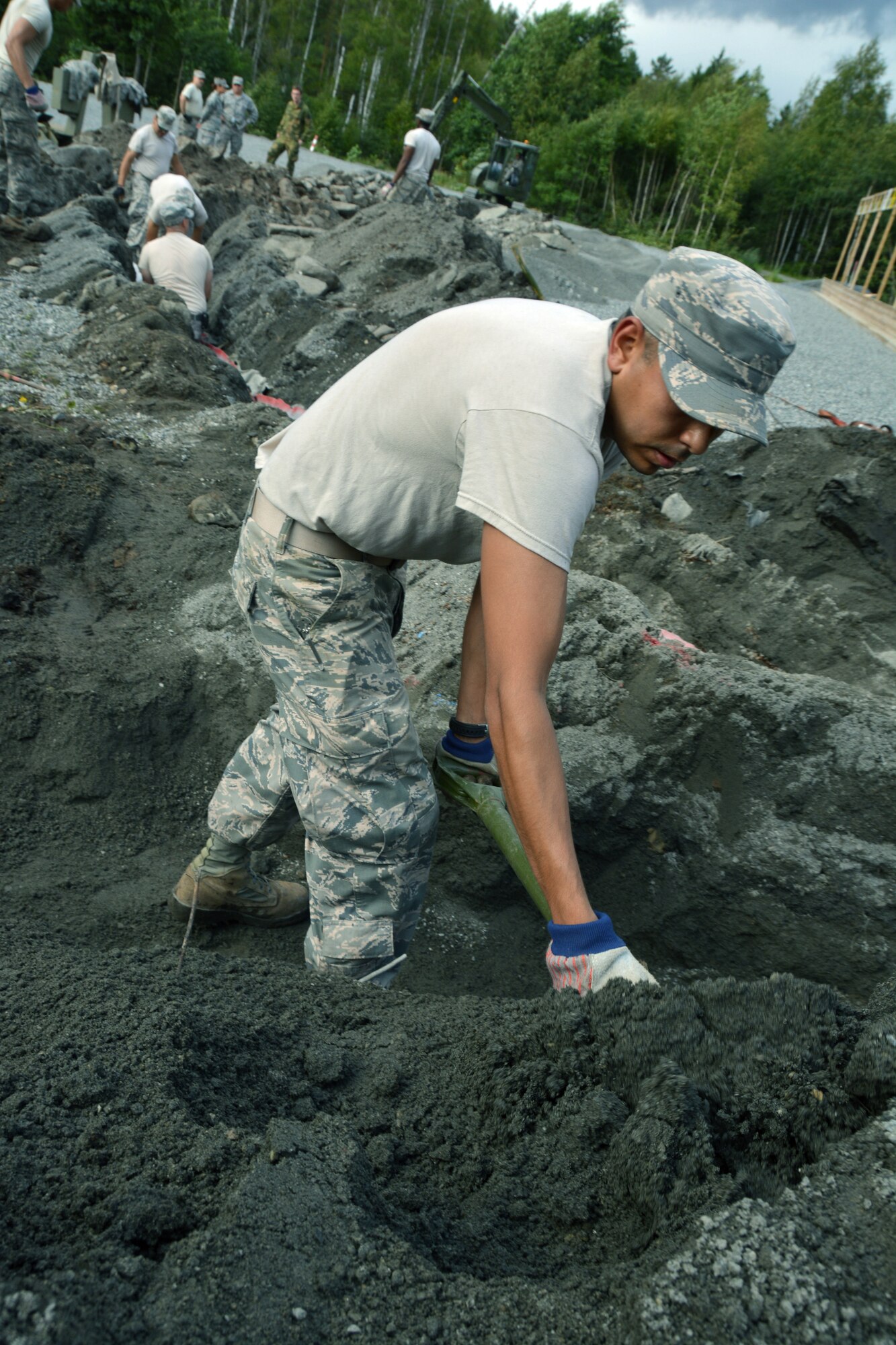 U.S. Air Force Airman 1st Class Steven Rubalcaba, an electrical systems technician assigned to the Texas Air National Guard’s 149th Civil Engineering Squadron, a subordinate unit of the 149th Fighter Wing, headquartered at Joint Base San Antonio – Lackland, Texas, uses a shovel to move dirt at Rygge Air Station, Norway, Aug. 12, 2013. 149th Fighter Wing’s 149th Civil Engineering Squadron was in Norway as part of the National Guard Bureau’s deployment for training (DFT) program to train with members of the Royal Norwegian armed forces. (U.S. Air National Guard photo by Staff Sgt. Phil Fountain / Released)