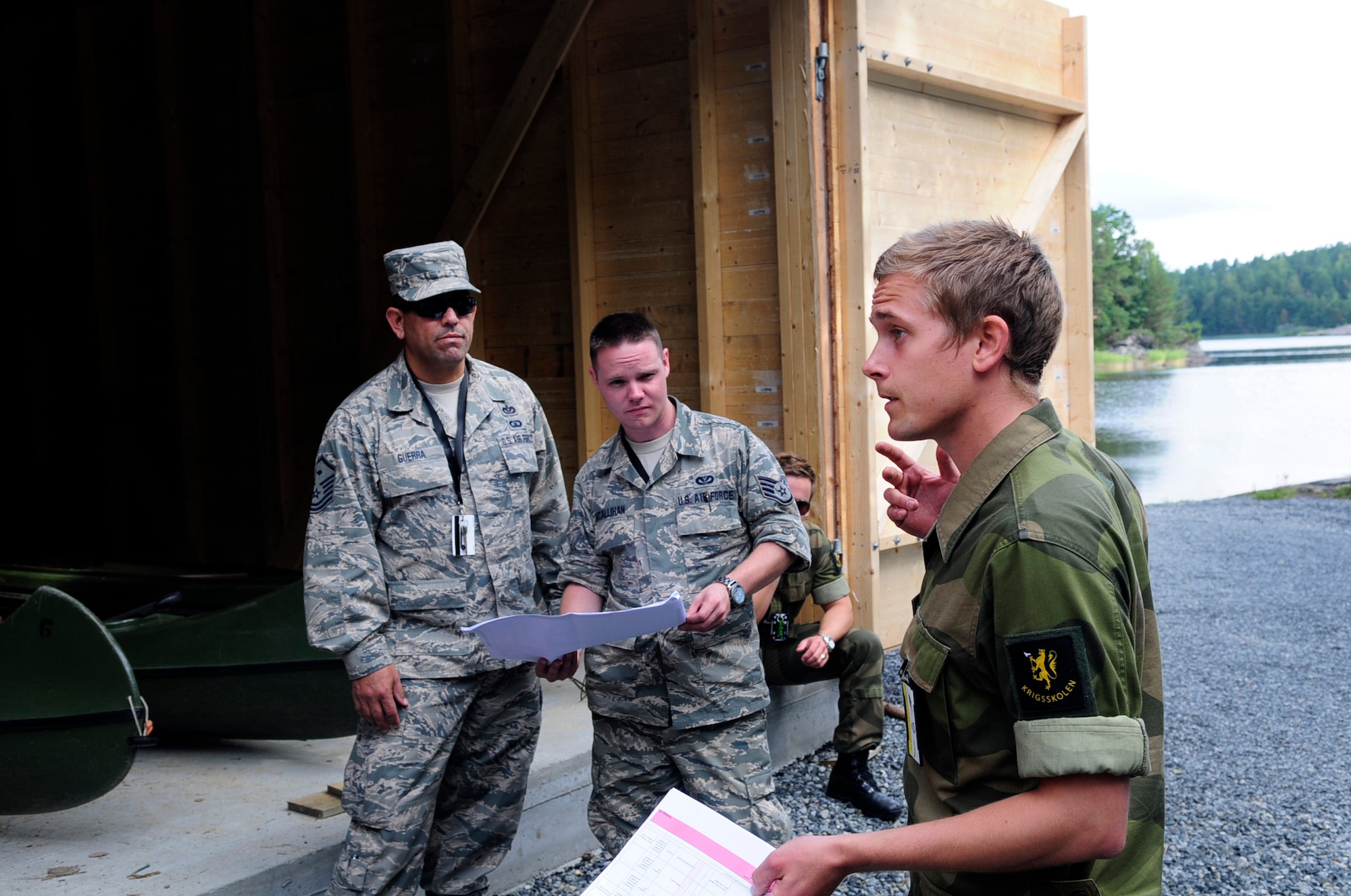 Cadet Kjetil Waal, a senior Royal Norwegian military cadet enrolled in the engineering program at the Norwegian Military Academy (Krigsskolen), at Camp Linderud, in Oslo, Norway, briefs members of the Texas Air National Guard’s 149th Civil Engineering Squadron, a subordinate unit of the 149th Fighter Wing, headquartered at Joint Base San Antonio – Lackland, Texas, on a construction project at Rygge Air Station, Norway, Aug. 12, 2013. The 149th Fighter Wing’s 149th Civil Engineering Squadron was in Norway as part of the National Guard Bureau’s deployment for training (DFT) program to train with members of the Royal Norwegian armed forces. Also featured in the photo are U.S. Air Force Master Sgt. Simon Guerra and U.S. Air Force Staff Sgt. Jonah McCallihan, members of the 149th Civil Engineering Squadron. (U.S. Air National Guard photo by Staff Sgt. Phil Fountain / Released)