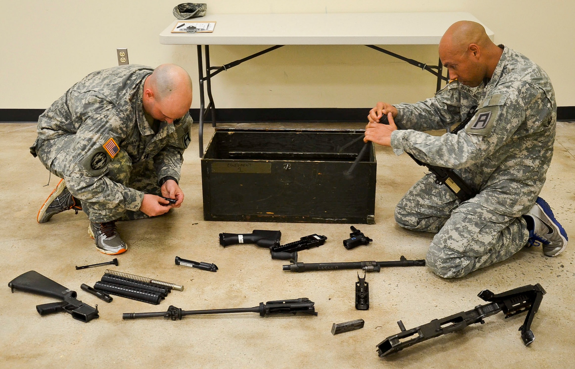 Capt. Curtiss Branham, 1-307th Infantry Regiment, left, and Chief Warrant Officer 3 Nicholas Bartling, 174th Infantry Brigade Headquarters and Headquarters Detachment, perform weapons assembly and functions check tasks during the 174th Inf. Bde.’s Best Officer Competition, Aug. 26-28, 2013, at Joint Base McGuire-Dix-Lakehurst, N.J. The officers received a footlocker with four completely disassembled and disorganized weapons (the M9 pistol; the M16 rifle; the M240 machine gun; and the M249 squad automatic weapon) and had to assemble and perform functions checks on each in eight minutes or less. (U.S. Army photo by Sgt. 1st Class Raymond Alston/Released)