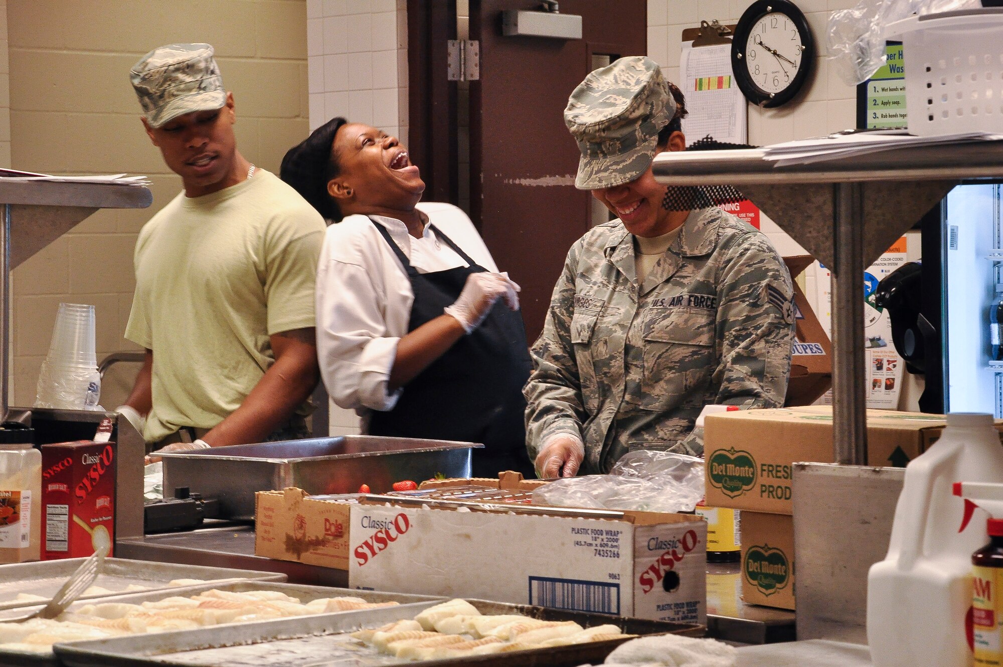 “Tee” Archie, a 19th Force Support Squadron food services employee, laughs during a conversation with Airman 1st Class Lonnie Burrell and Senior Airman Jennifer Burgos, also 19th FSS food services employees, Aug. 19, 2013, at Little Rock Air Force Base, Ark. The dining facility hours are Monday through Sunday from 6:30 a.m. to 6:30 p.m. (U.S.  Air Force photo by Senior Airman Regina Agoha) 