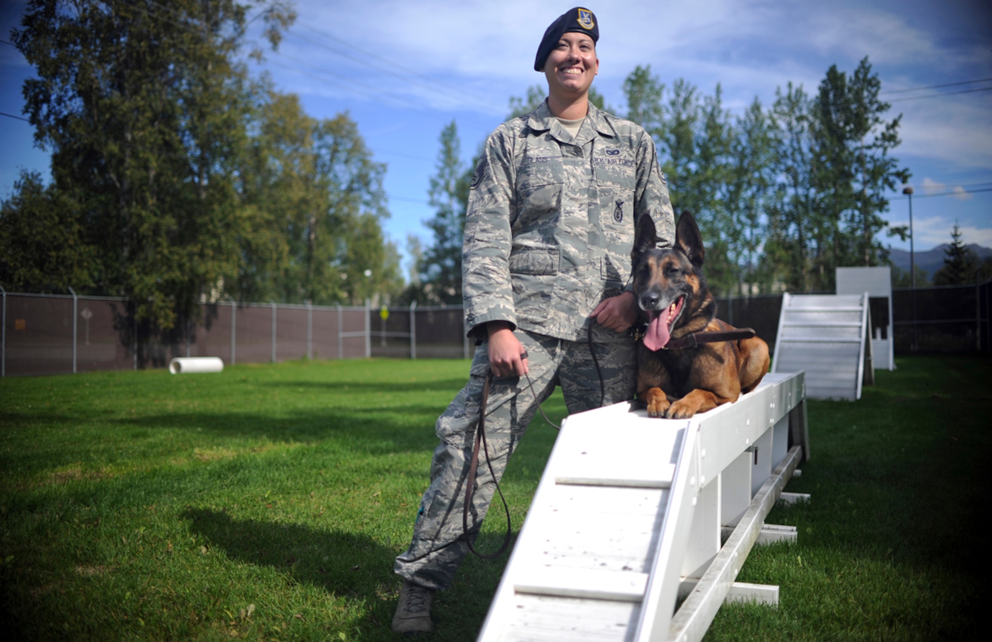 Air Force Staff Sgt. Stacy Glass, assigned to the 673d Air Base Wing Security Forces Squadron, a native of Pittsburgh, Penn., poses with Chase, her military working dog, on Joint Base Elmendorf-Richardson, Aug. 26, 2013. Security Forces Airmen continually train with their K9 counterparts to keep their teams flexible to respond to law enforcement emergencies, and for overseas deployments. (U.S. Air Force photo by Justin Connaher/Released)