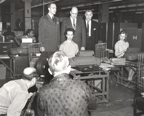 A television crew that featured the Air Reserve Records Center in a documentary filmed an employee performing her duties while senior leaders look over her shoulder at the York Street building in Denver, Colo., in 1958. (U.S. Air Force photo)

